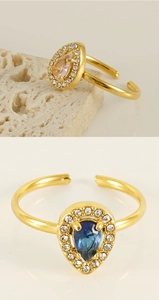 Detailed close-up of 18K gold-plated adjustable rings with pear-cut pink and blue zircons