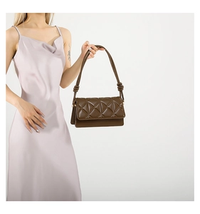 Detail showing deep brown crossbody bag with plaid quilting and knotted shoulder strap