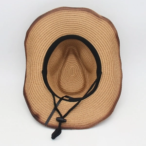 Detail view of woven straw sun hat interior with adjustable black chin strap