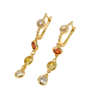 Gold-plated bohemian earrings with colorful orange and yellow zircon tassels on white background