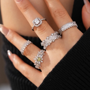 Macro shot of silver-colored rings with zircon flower and geometric textured designs