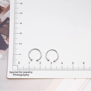 Detailed macro view showing the S925 sterling silver ear cuff diameter on a scale card