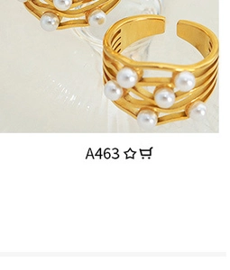 Detail of adjustable gold-finish rings featuring multi-pearl inlay and minimalist band