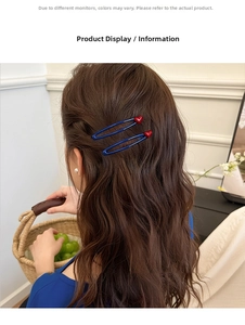 Close-up of blue oval hair clips with red hearts worn on brown wavy hair by a model