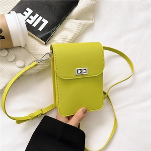 Minimalist yellow leather phone bag with silver twist lock on white knitted fabric