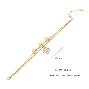 Detail view of double-layer stainless steel bracelet with clover and crystal charms