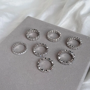 Close-up of S925 sterling silver rings with zircon stones on gray velvet tray