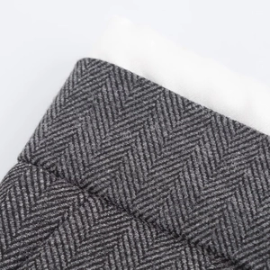 Close-up of gray herringbone fabric texture with thick white lining on wide leg pants
