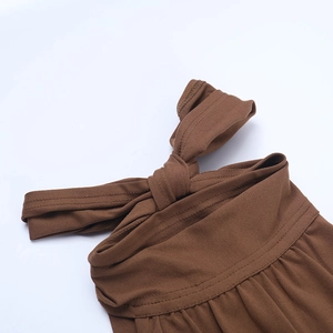 Détail d'une robe dos nu marron montrant le nœud papillon et les textures plissées