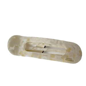 Elegant marble white acetate hair clip with gold logo on a clean white background
