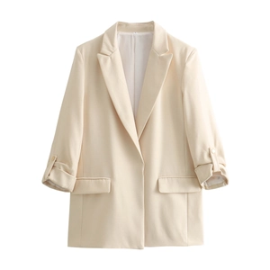 Flat lay of a beige casual blazer with unique rolled sleeves and decorative gold buttons