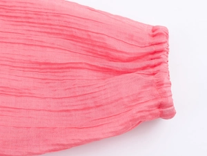 Macro detail of pink bohemian ruffled sleeve cuffs with elastic texture and fine stitching
