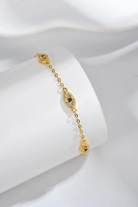 Detailed macro view of the gold Evil Eye bracelet with blue and white crystals