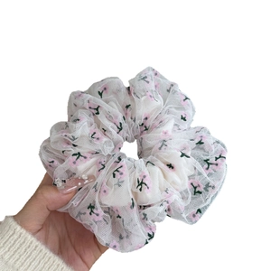 Chouchou en résille fleurie avec motif rose et vert pour coiffures de printemps