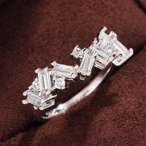 Macro shot of silver-tone ring featuring geometric zircon stones on brown velvet