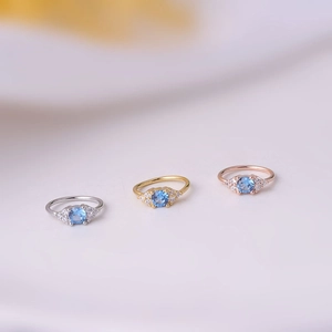 Detailed view of silver, gold and rose gold nose rings with blue and clear zircon stones