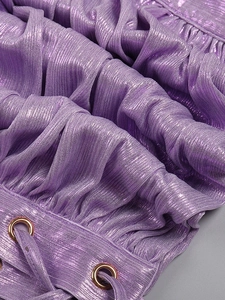 Macro detail of purple metallic fabric featuring shirred texture and golden eyelets