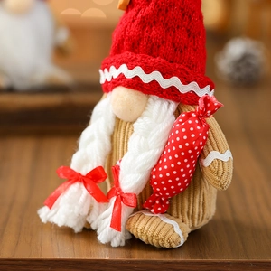 Macro detail of Christmas gnome doll showing knitted textures and plush beard on wood surface