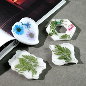 Detailed view of DIY resin molds with real dried flowers in geometric silicone shapes