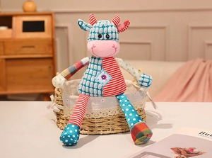 Close-up of a patchwork cow plush toy sitting in a lace-lined basket at home