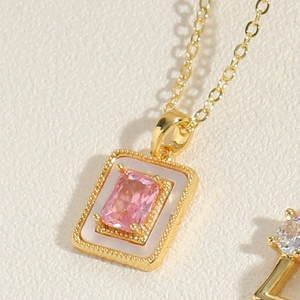 Detailed close-up of a gold necklace featuring a pink zircon set in a rectangular pendant