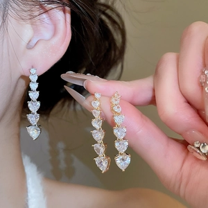 Detail showing gradient heart-shaped drop earrings with 18K gold plating and zircon