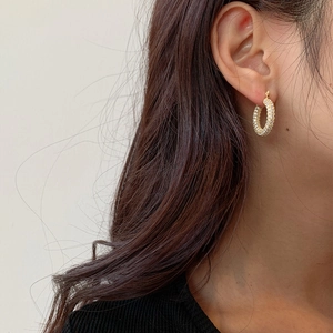 Elegant gold U-shaped earrings with pave-set zircons worn by a model for daily wear
