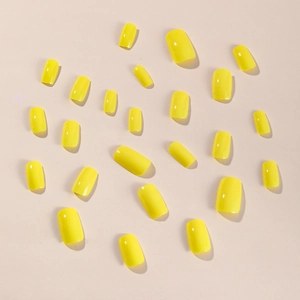 Glossy bright yellow press-on nails set in medium-long length on a neutral background