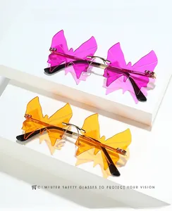 Detail of rimless butterfly sunglasses with gold hardware and pink and orange lenses