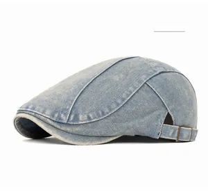 Detail view of the bronze metal adjustment buckle and stitching on blue denim ivy cap