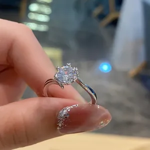 Detailed close-up of a silver six-prong crown setting ring with a large round sparkling diamond