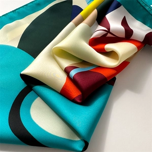Detailed view of the vibrant floral print and fine rolled edge of this satin square scarf