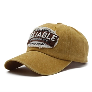 Close-up of vintage yellow washed cotton baseball cap with reliable patch embroidery