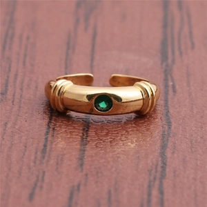 Detail of gold open ring featuring a round green gemstone and micro-inlaid zircons
