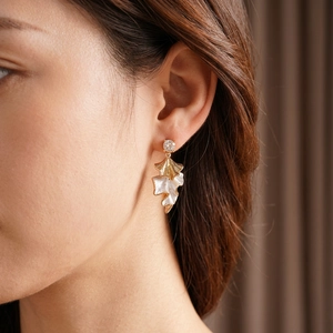 Elegance leaf earrings with zircon studs and gold-white contrast finish on model