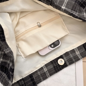 Detail view of plaid tote bag interior with magnetic clasp and zip pocket for phone