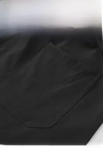 Close-up of back pocket details on black loose cotton trousers with clean stitching