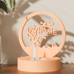 Dettaglio portacandele HOME arancione caldo con sagoma di albero e base per tealight