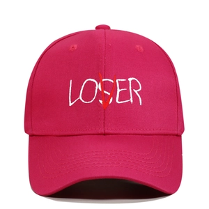 Detailed view of white LOSER and red V embroidery on a dark pink cotton baseball cap
