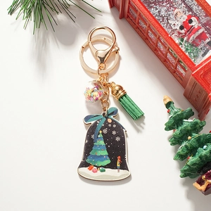 Weihnachtsglocken Schlüsselanhänger mit grüner Quaste und Baummotiv auf weißem Hintergrund