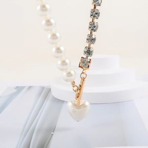 Asymmetric faux pearl necklace with rhinestones and heart pendant on OT buckle
