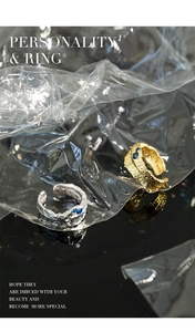 Detail of irregular textured S925 silver rings in gold and silver with blue zircons