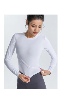 Détail de l'ourlet croisé asymétrique sur haut de yoga blanc cintré à manches longues