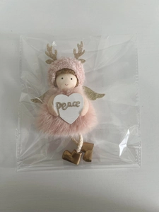 Close-up of a pink plush angel doll ornament with golden antlers and a peace heart sign