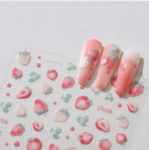 Detailed view of pink strawberry and floral pattern nail art stickers on clear sheet
