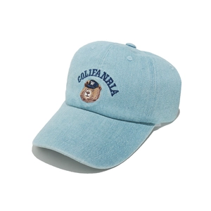 Dettaglio del ricamo dell'orso e del testo sulla berretta da baseball in denim blu chiaro