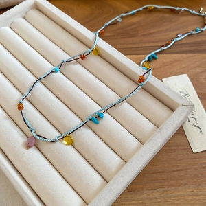 Macro shot of colorful stone pendants on a handcrafted woven bohemian cord necklace