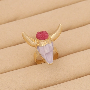 Detailed view of bohemian bull head ring featuring pink gemstone and vintage gold finish