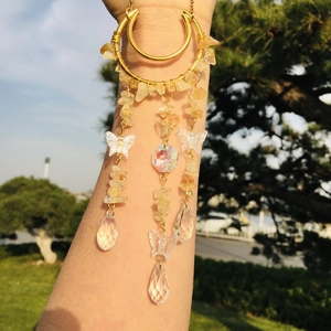 Detail of arm cuff with dangling yellow citrine stones and crystal butterfly pendants