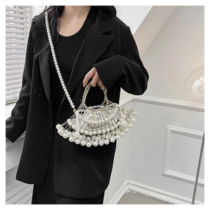Detail of beaded pearl handbag with metal frame and drawstring inner bag on model
